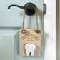 tooth fairy door hanger is hanging on a door and made of wood laser engraved with tooth fairy stop here has a section for a child to insert a tooth and for the tooth fairy to insert money