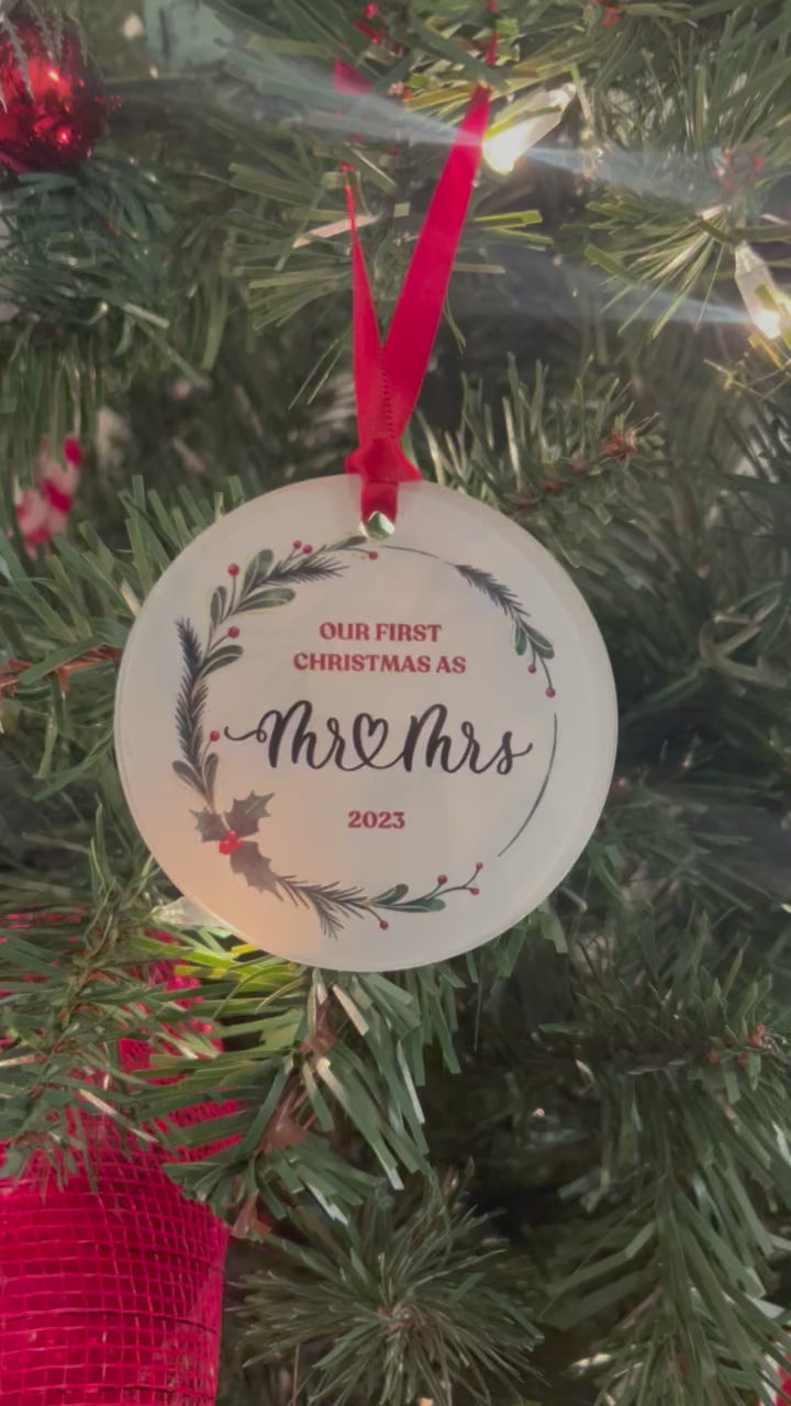 Video of acrylic ornament hanging on a tree that says Our first Christmas as Mr and Mrs 2023, surrounded by a holly wreath.